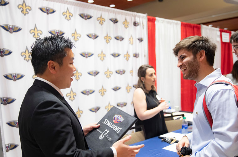 A 鶹ҹ students talks to a career recruiter from the professional sports teams New Orleans Saints and Pelicans