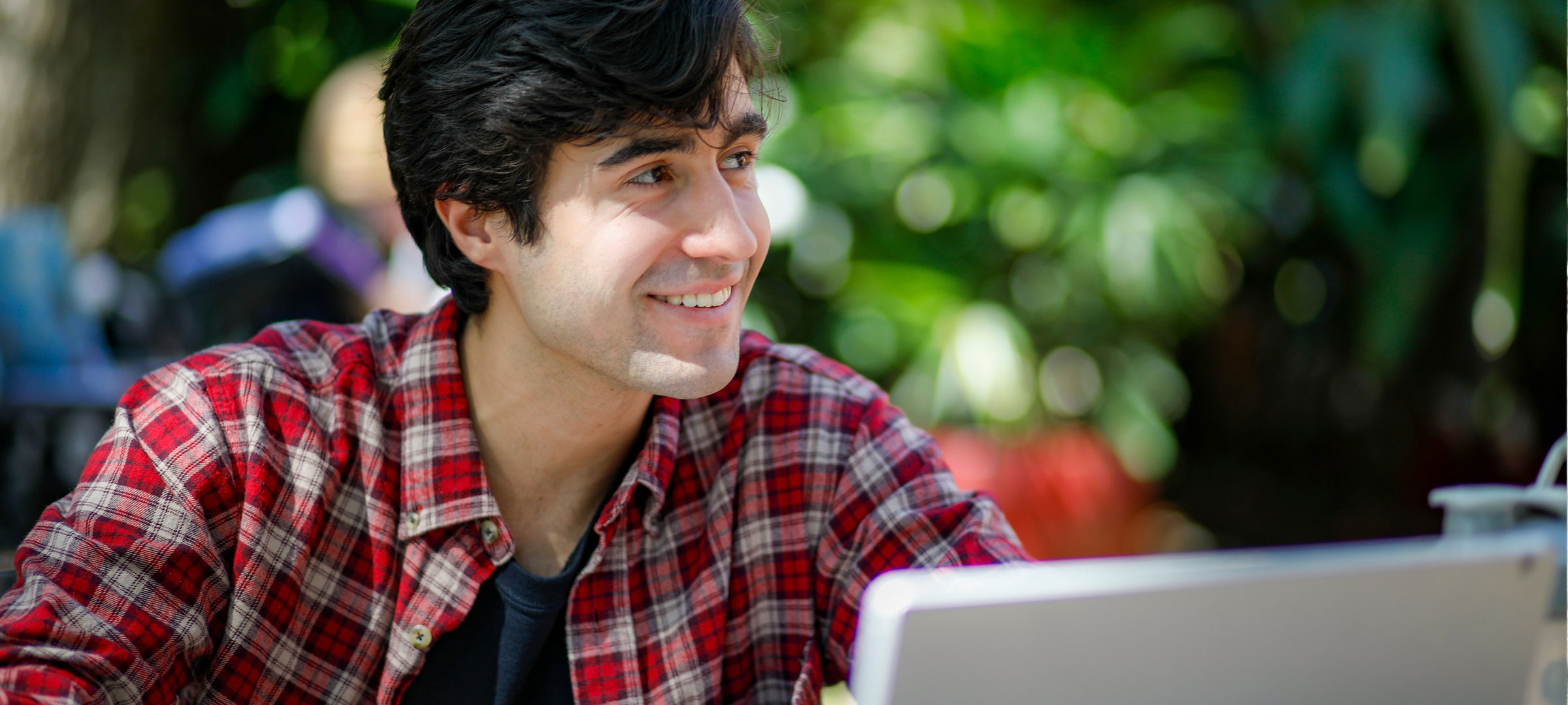 鶹ҹ student smiles while studying in front of his computer