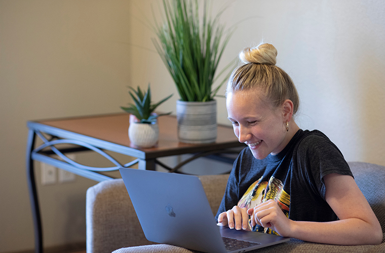 鶹ҹ student using laptop in residence hall wifi