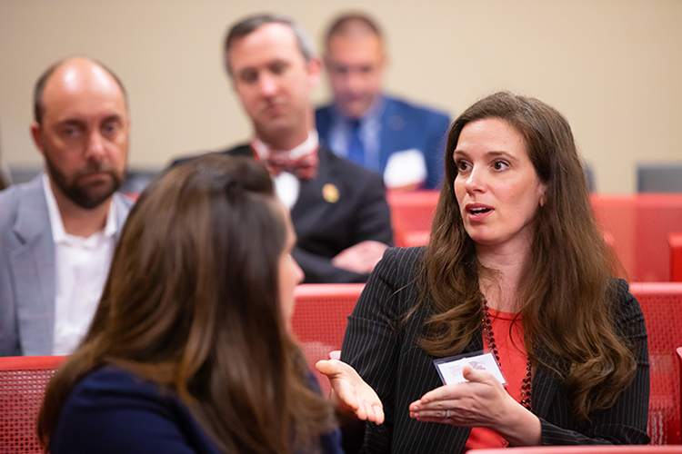 鶹ҹ faculty and staff engage in conversation at a conference