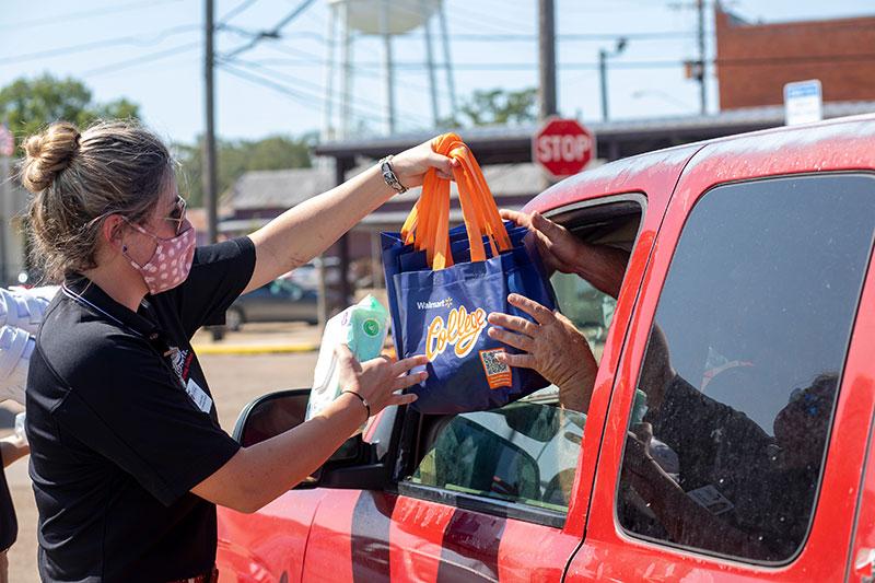 A 鶹ҹ student hands donated groceries to a Louisiana resident in need