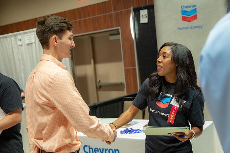 A 鶹ҹ student shakes hands with a recruiter at a university career fair