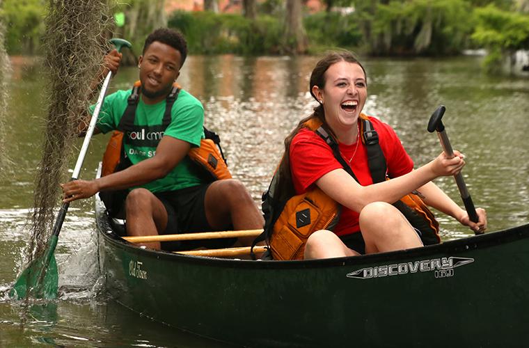 Students participate in canoe races in 鶹ҹ's Cypress Lake
